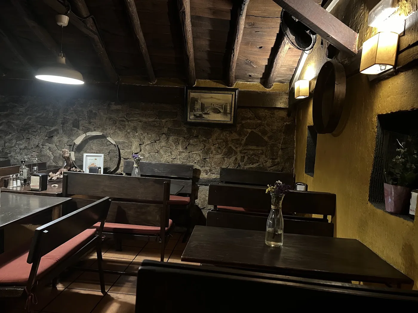 El comedor de Il Tizzone, con la pared de piedra y la madera